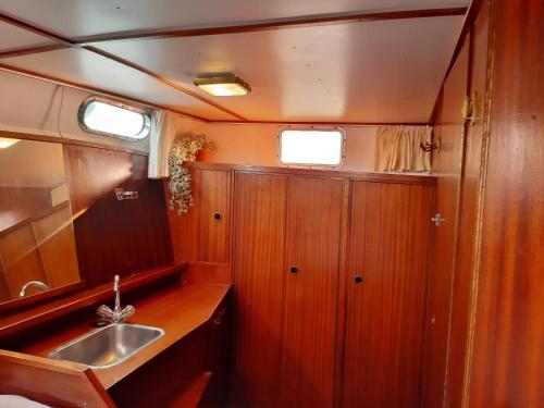 una pequeña cocina con lavabo y espejo en Motor Yacht Almaz en Ámsterdam