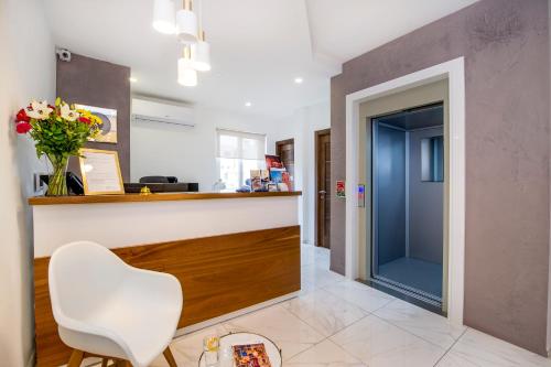 a lobby with a counter and a white chair at South Wind Guesthouse in Marsaxlokk