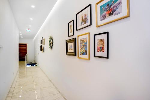 a hallway with framed pictures on a wall at South Wind Guesthouse in Marsaxlokk