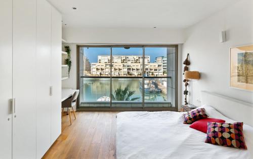 Schlafzimmer mit einem Bett und Blick auf ein Gebäude in der Unterkunft Lagoon View 3bd Huge Family Apartment in Herzlia
