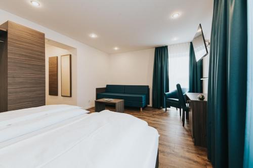 um quarto de hotel com uma cama, uma cadeira e uma secretária em Hotel Restaurant Adria Stuben Brühl em Brühl