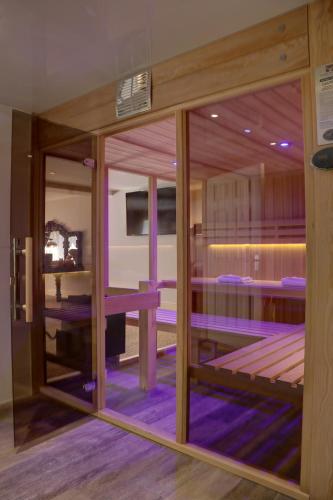 a room with a glass door with a room with purple beds at Best Western Premier Doncaster Mount Pleasant Hotel in Doncaster
