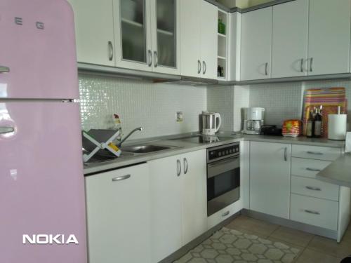 シビリにあるSpiti Kiposのキッチン(白いキャビネット、ピンクの冷蔵庫付)