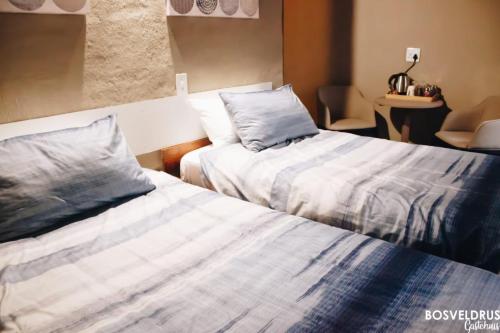 dos camas sentadas una al lado de la otra en una habitación en Bosveldrus Gastehuis, en Vaalwater