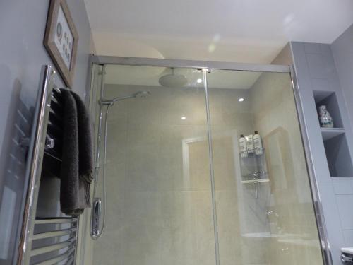 a shower with a glass door in a bathroom at Bed and Breakfast accommodation near Brinkley ideal for Newmarket and Cambridge in Newmarket