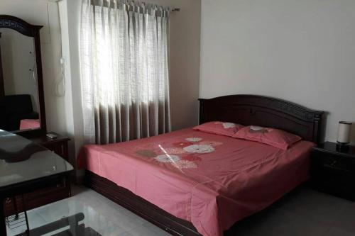 a bedroom with a bed with pink sheets and a window at Impressa on Shah in Dhaka