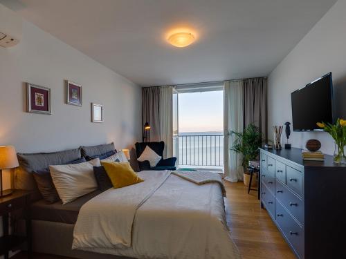 een slaapkamer met een groot bed en een groot raam bij Bella Vista Premium Apartment in Poreč
