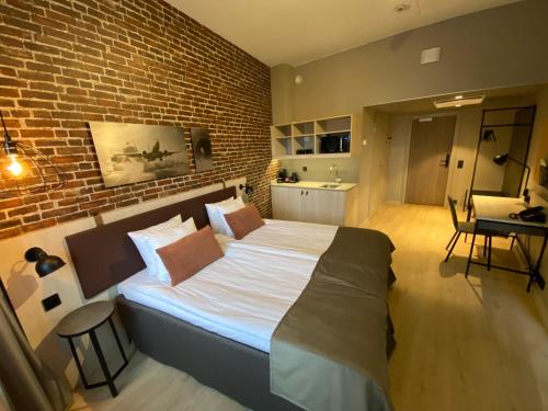 a bedroom with a large bed with a brick wall at Skyline Airport Hotel in Vantaa
