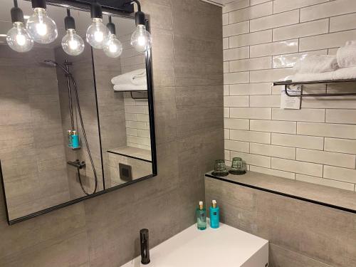 a bathroom with a sink and a shower and a mirror at Skyline Airport Hotel in Vantaa