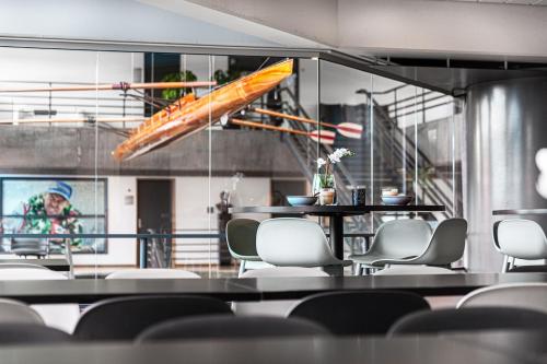 a dining room with a table and chairs and a kayak on the wall at Idrættens Hus Hotel og Konference in Brøndbyvester