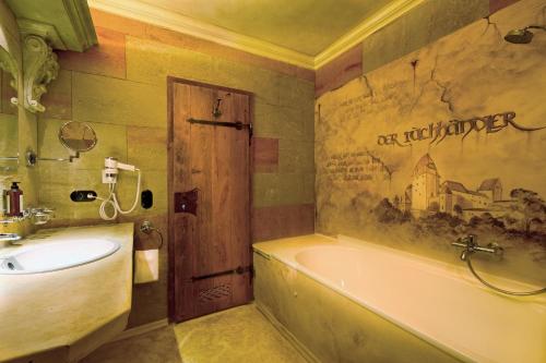 a bathroom with a bath tub and a sink at Simones Hotel Fürstenhof in Landshut