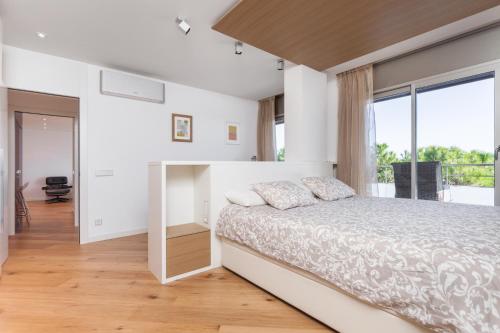 a bedroom with a bed and a large window at HHBCN Beach Apartment Gava #2 in Gavà