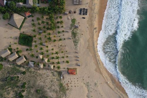 an overhead view of a beach with umbrellas and the ocean at Whisky Point Resort in Arugam Bay