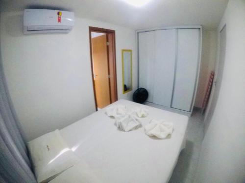 uma cama branca num quarto com um espelho em STUDIO 102 - Manaíra em João Pessoa