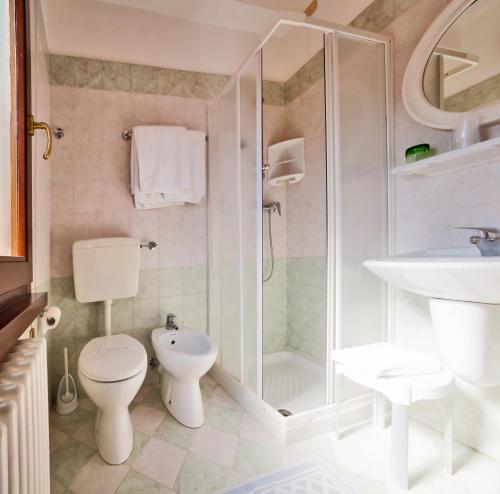een badkamer met een toilet, een douche en een wastafel bij Hotel Regina in Caorle