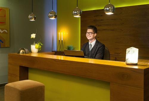 a man sitting at a desk with a laptop at Hotel Radun in Luhačovice