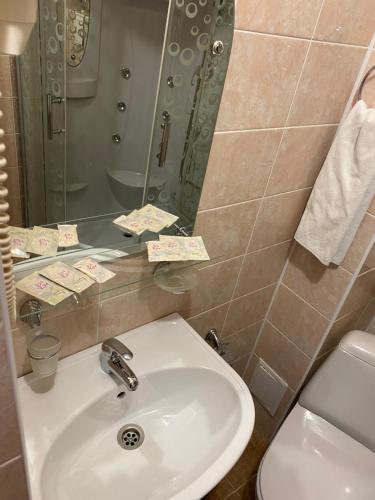 y baño con lavabo, aseo y espejo. en Tsentralnaya Hotel, en Sergiyev Posad