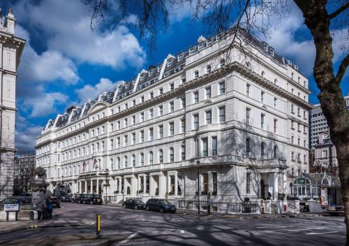 Corus Hyde Park Hotel في لندن: مبنى ابيض كبير على جانب شارع