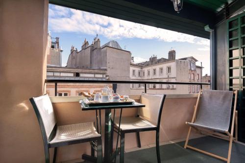 a table and chairs on a balcony with a view at Grand Hotel de l'Opera - BW Premier Collection in Toulouse