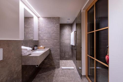 a bathroom with a sink and a shower at Brunnenhof Luxury Apartments in Lech am Arlberg
