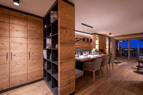 a dining room with a table and chairs and wooden walls at Brunnenhof Luxury Apartments in Lech am Arlberg