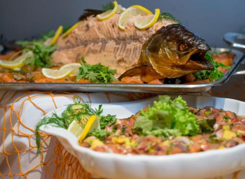a table topped with a plate of food with a fish at Hotel Deichgraf in Cuxhaven