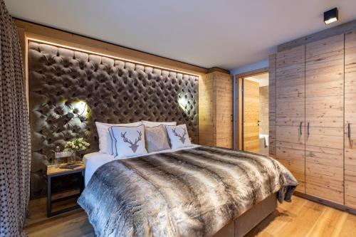 a bedroom with a large bed and a large wall at Brunnenhof Luxury Apartments in Lech am Arlberg