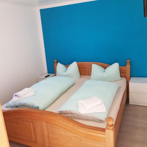 2 camas individuais num quarto com uma parede azul em Bungalow Streuwiese em Warnemünde