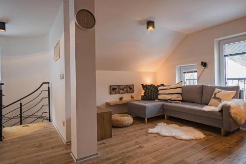 uma sala de estar com um sofá e uma escada em Ruprecht Apartment em Vrchlabí