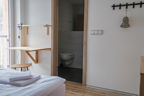 a bedroom with a door leading to a bathroom with a toilet at Ruprecht Apartment in Vrchlabí