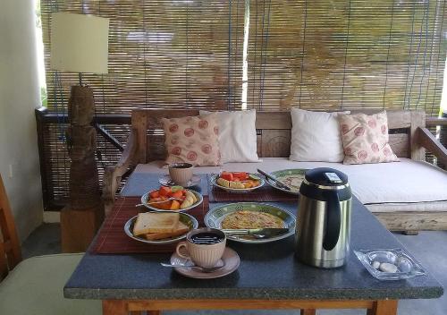 a breakfast table with plates of food on a couch at Waiara Village Guesthouse in Maumere