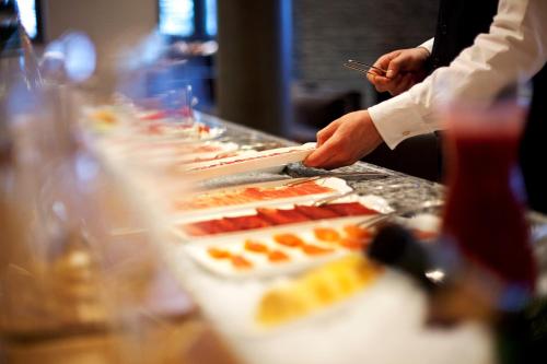 a person preparing food on top of a buffet at The Omnia in Zermatt