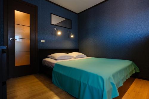 a room with a bed with a blue wall at ОК! Никитина, 20 №1 in Tomsk