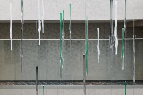 a bunch of green and white umbrellas hanging from a wall at Hotel Passage in Brno