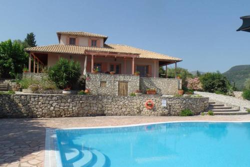 a house with a swimming pool in front of a house at Lefkada Seaview Villa in Lygia