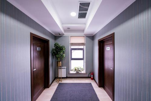 a hallway with two doors and a rug at Oasis Residence in Bishkek