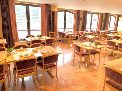 a dining room with tables and chairs and windows at Hôtel du Lac in Butgenbach