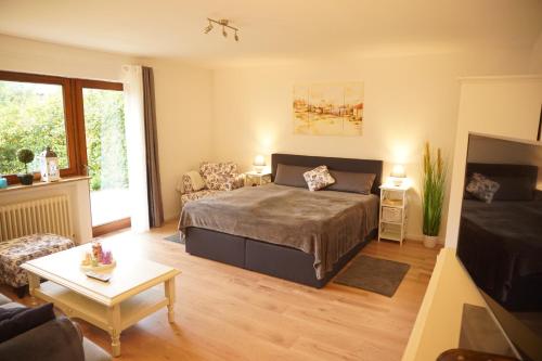 a bedroom with a bed and a living room at Haus zur Sonne in Bad Bertrich