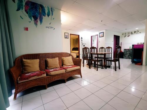 a living room with a couch and tables and chairs at Sea & Wave #2 Coral Bay Apartment in Pangkor
