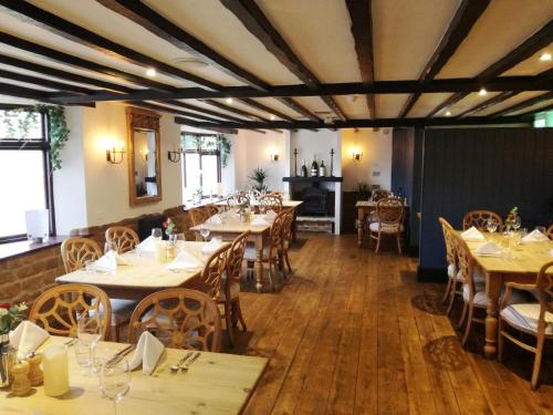a dining room with wooden tables and chairs at The Marquess of Exeter in Uppingham