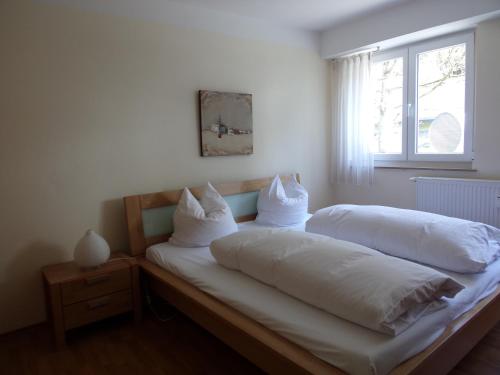 a bedroom with two beds with white sheets and a window at Linden 1 in Monschau