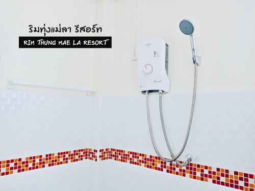 a shower in a bathroom with a red and white tile border at ริมทุ่งแม่ลา รีสอร์ท Rim-Thung-Mae-La-Resort in Sing Buri