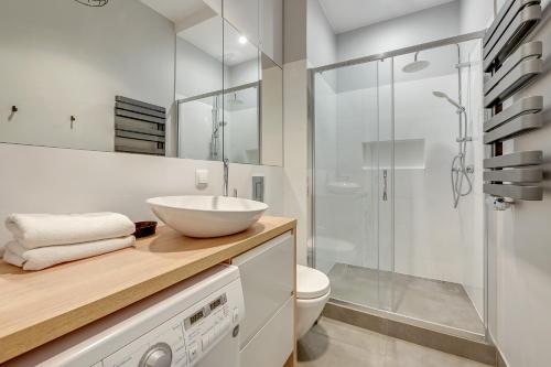 a bathroom with a sink and a toilet and a shower at Grand Apartments - Patio Mare Apartments in Sopot