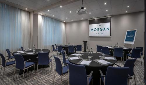 a conference room with round tables and blue chairs at The Morgan Hotel in Dublin