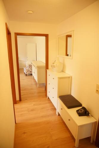 a room with a white dresser and a mirror at Haus zur Sonne in Bad Bertrich