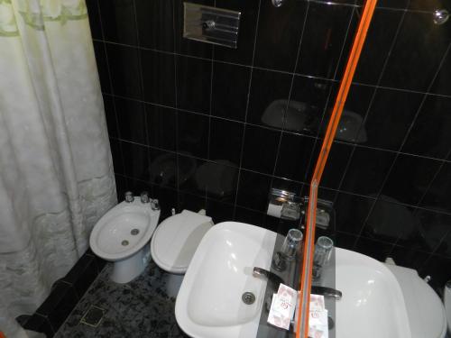 a bathroom with a sink and a toilet at Sun-Shine Hotel in San Clemente del Tuyú