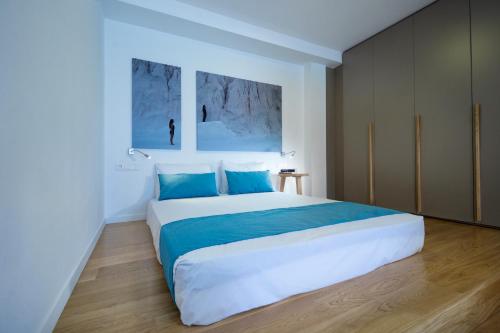 a bedroom with a large bed with blue pillows at Seametry Apartments in Souda