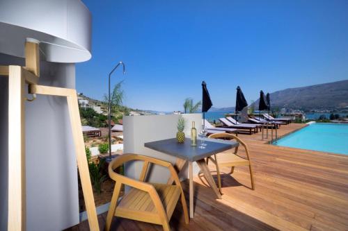 a patio with a table and chairs and a pool at Seametry Apartments in Souda