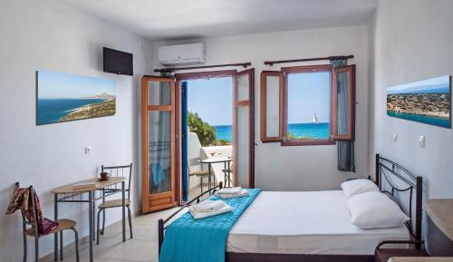 a bedroom with a bed and a view of the ocean at Ammoudia Studios in Agiassos