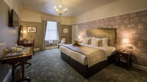 a bedroom with a large bed with a cat sitting on it at Old Hall Hotel in Buxton